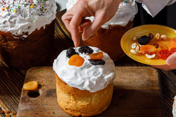 Cook decorates Easter cake with dried fruits .
