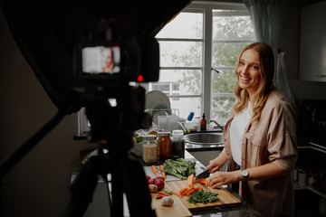 Young female blogger vlogger and online influencer recording video content on healthy food