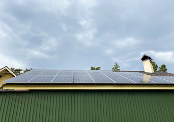 Solar panels mounted on the roof of a large house.