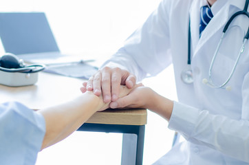 Doctors wear stethoscope, hand to hand, encouraging patients to be cured from illness