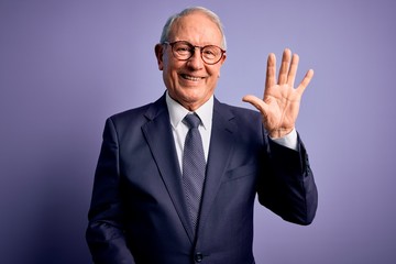 Grey haired senior business man wearing glasses and elegant suit and tie over purple background showing and pointing up with fingers number five while smiling confident and happy.