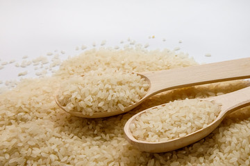 Rice in wooden bowl on white background. close up shot. Jasmine rice for cooking.