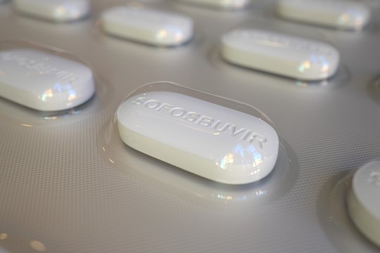 Sofosbuvir generic drug pills in blister pack, close-up 3D rendering