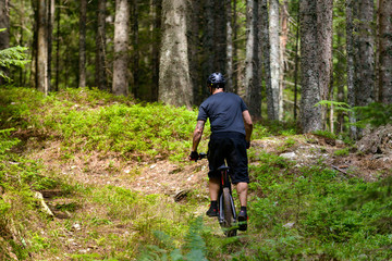Fototapeta na wymiar Male cyclist with mountainbike up in forest