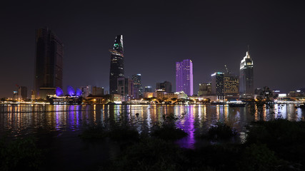 Naklejka premium Modern architecture in downtown of Ho Chi Minh City, with river Saigon at nigh