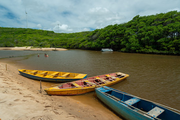 Guaju river, Sagi beach, Baia Formosa, near Natal and Pipa beach, Rio Grande do Norte, Brazil on April 19, 2015. Colorful boats and tourists