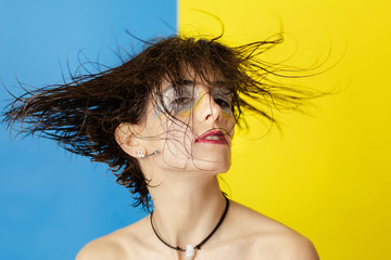 Female fashion model with creative make up shaking wet hair. Studio shot of girl with wet hair. Summer sea concept. 