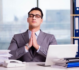 Businessman meditating in the office