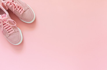 Pink nubuck sneakers isolated on a pink background, seasonal shoes for walking and sports, top view