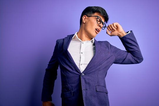 Young handsome business man wearing jacket and glasses over isolated purple background stretching back, tired and relaxed, sleepy and yawning for early morning