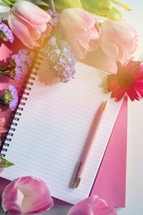 Empty notebook spring flowers, cup of coffee. Mockup notepad on pink background. Still life. Spring romantic mood. Colorful light. Top view. Copy space