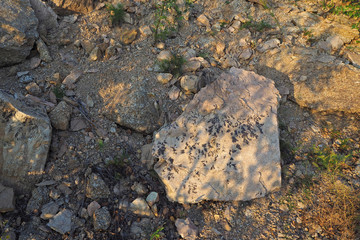 The stone with natural oxide ornament and stones of different sizes on the ground.