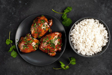 grilled sweet chicken thighs and  cooked rice on a stone background. Asian food