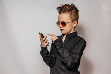 a fashionable guy in sunglasses and a black shirt with a cool hairstyle looks at the phone and...