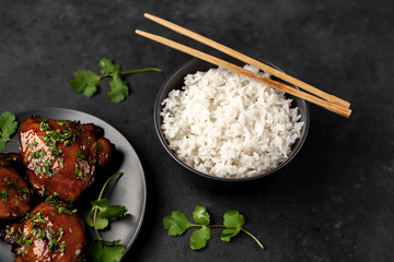 grilled sweet chicken thighs and  cooked rice on a stone background. Asian food