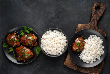 grilled sweet chicken thighs and  cooked rice on a stone background 
with copy space for your text. Asian food