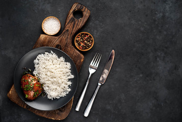 grilled sweet chicken thighs and  cooked rice on a stone background 
with copy space for your text. Asian food