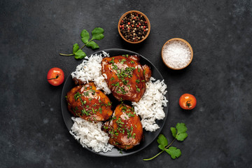 grilled sweet chicken thighs and  cooked rice on a stone background 
with copy space for your text. Asian food