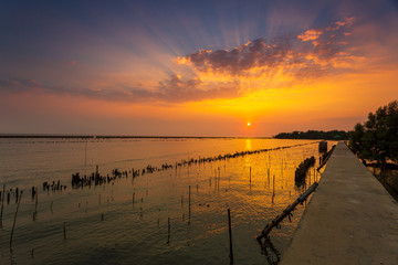 Obraz premium Sunset over the lake in the village ,The bridge stretches out to sea and sunsets in the evening 