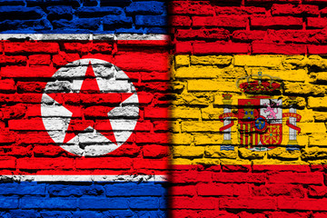 Flag of North Korea and Spain on brick wall