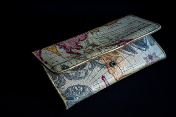 close view of a purse with travelling pattern on dark black background