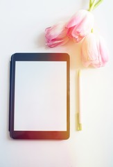 Pretty Styled Desktop Mockup tablet, pink spring tulips flowers on white background, great for lifestyle bloggers and small businesses. Blank screen, copy space. Home office.