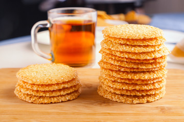 Fototapeta na wymiar Sesame cookies on the table with cup of black tea on background served at sunny morning