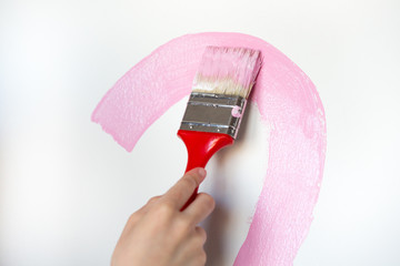 child draws a pink paint line, heart. Paint brush stroke on white background.