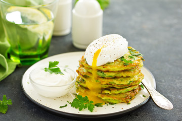 Fritters from zucchini and greens with poached egg. Healthy breakfast. Selective focus