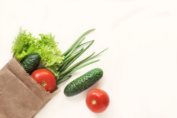 Food delivery. Fresh vegetables. Healthy healthy food.Paper bag with vegetables and other foodstuffs on a white background with copy space top view..