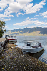 Pleasure boats at the pier of a mountain lake. Russia, the Republic of Altai, Ulagansky District, Lake Teletskoye, Cape Kyrsay