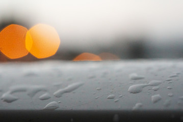 Barandilla mojada con gotas de lluvia y desenfoque de fondo