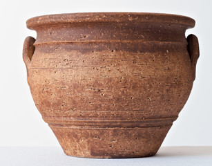 ceramic flowerpot in the shape of an ancient clay vase in brown color