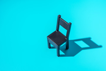 Concept Secretary`s Day, black chair on a mint background, symbol of work in the office, hard light, minimalism.