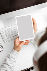 Naklejka premium Digital tablet with a blank screen in the hands of a girl. Place for text.
