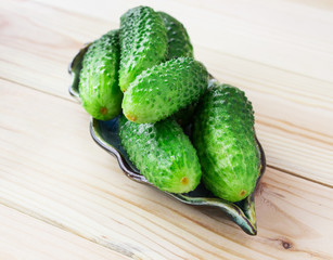 Cucumber gherkins on a light wooden background. Country style. View from above. Place for text.