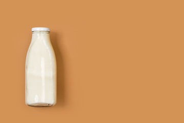 Botella de leche natural y fresca sobre un fondo liso marrón aislado. Vista superior. Copy space