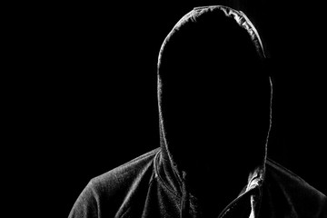 Man with no face in hoodie. Dark, black background