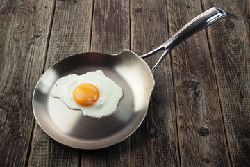 Eggs from one egg on a steel pan on a wooden background