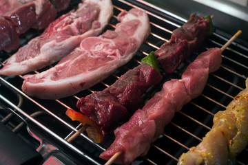 closeup of beef skewers on electric barbecue at home