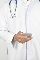 Doctor with stethoscope holding mobile phone close up.