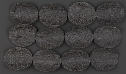 black potato chips isolated on black background