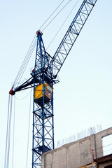 Crane. Self-erection crane near concrete building. Construction site.