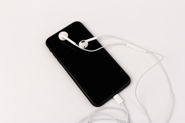 Creative flat lay photo of workspace desk with earphones and mobile phone