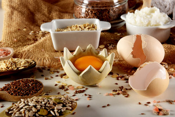 raw egg yolk accompanied by various seeds and egg shells
