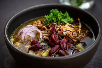 Bean soup with smoked pork, potatoes, herbs, onion
