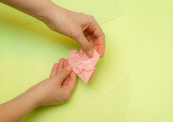 Origami pink heart on a green background, step by step instructions. as great idea for a hand made diy Valentine s Day, Mothers day gift. Step 24