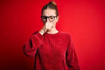 Young beautiful redhead woman wearing casual sweater over isolated red background feeling unwell and coughing as symptom for cold or bronchitis. Health care concept.