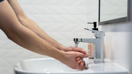 Mycie rąk w białej łazience.