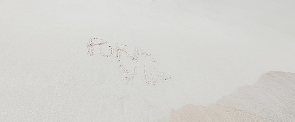 Sign of Pura Vida written on the white sand of Costa Rica's beach.